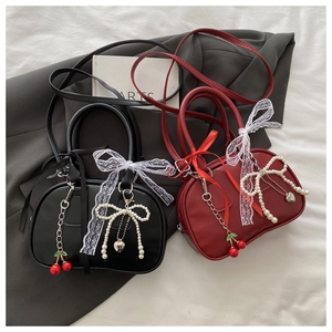Detail of vintage leopard print pillow bags in black and red with pearl cherry charms