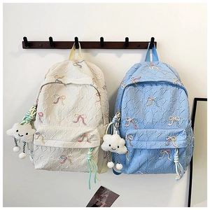 Detail of striped school backpack with cute cloud plush charm and bow embroidery