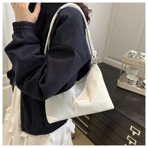 Détail du sac à bandoulière blanc plissé avec rayures verticales et bandoulière en corde