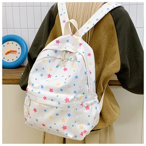 Detail of white star print canvas backpack featuring side pockets and adjustable straps