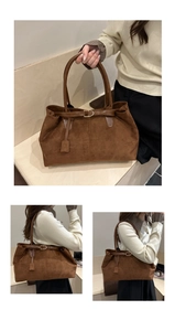 Detail view of brown suede tote bag with leather straps and golden D-ring buckle hardware