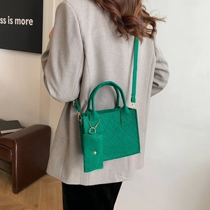 Detail der grünen gesteppten Filzhandtasche mit Mini-Börse am Umhängeriemen