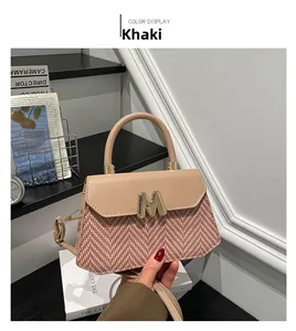 Détail du sac kaki avec texture tissée, rabat en cuir PU et logo M en métal doré