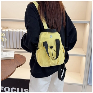 Detail view of the yellow mini nylon backpack with drawstring closure on model