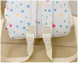 Detail of adjustable shoulder strap buckle on star print backpack for school girls