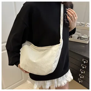 Minimalist white corduroy crescent crossbody bag with texture detail shown on model
