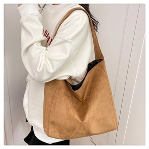 Detailed view of the brown suede tote bag texture and large shoulder strap capacity