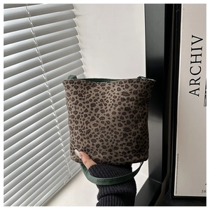 Detalle de la textura de leopardo y el asa de cuero verde oscuro del bolso de mano