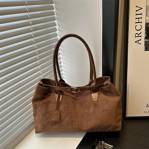 Vintage brown faux suede tote bag with slim leather handles in a minimalist studio setting
