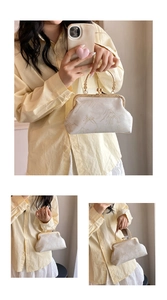 Detail of white fabric handbag with landscape print and elegant gold metal clasp