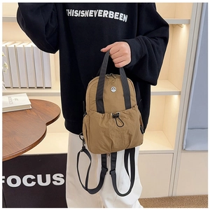 Detail of khaki nylon backpack with adjustable straps and front drawstring pocket
