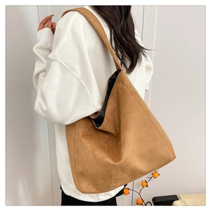 Detailed texture of brown suede tote bag featuring wide shoulder strap and soft touch