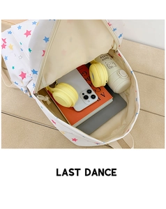 Spacious interior of white star print backpack showing storage for laptop and headphones