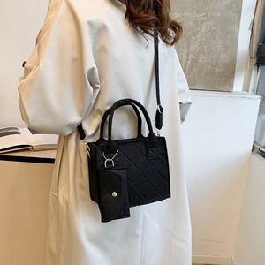 Detail einer schwarzen gesteppten Wolltasche mit passender kleiner Geldbörse als Anhänger