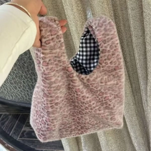 Close-up of pink leopard print faux fur handbag with black and white checkered lining