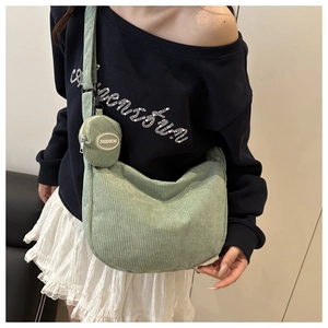 Detail of green corduroy crossbody hobo bag with a matching small round fashion coin purse
