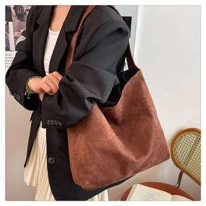 Detail view showing the large capacity and soft drape of the brown suede tote bag