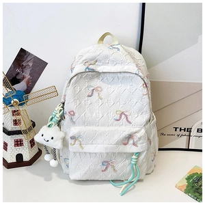 Close-up of white quilted backpack with colorful butterfly embroidery and plush cloud charm