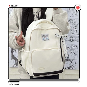 Cream school backpack with black base and polka dot bow accessory on comic background