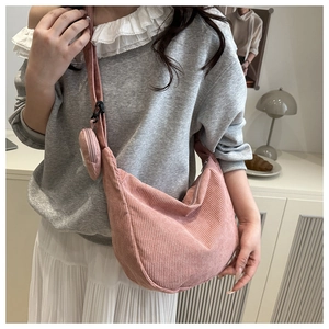 Detail of pink corduroy shoulder bag with matching round coin purse shown on model