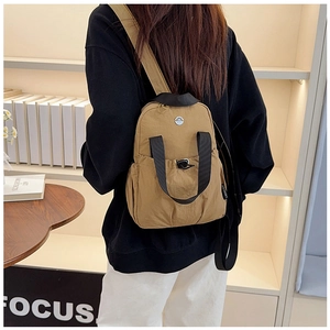 Detail of khaki nylon travel backpack featuring top handle and adjustable straps