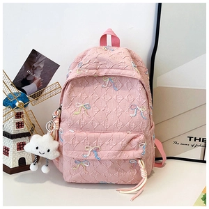 Detail of pink striped backpack featuring quilted pattern and embroidered bows with charm