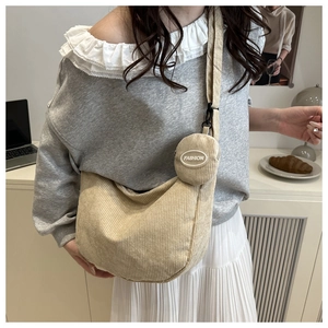 Detail of beige corduroy crossbody bag featuring a detachable round zipper coin purse
