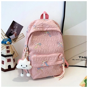 Detail of pink quilted backpack with colorful embroidered bows and plush cloud charm
