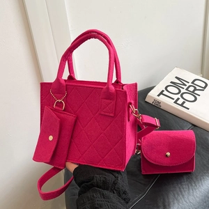 Detailansicht des fuchsiafarbenen Filztaschen-Sets mit Steppmuster und Goldbeschlägen