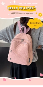 Detailed view of pink nylon backpack featuring multi-pocket structure and diagonal zipper