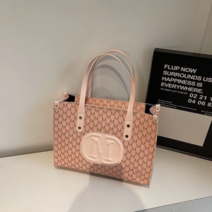 Pink tote bag with embossed M logo and all-over letter print on white marble