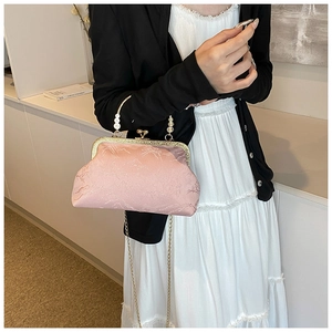 Detailed macro view of pink jacquard silk fabric and elegant pearl handle on retro bag