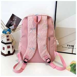 Close-up of pink striped backpack with butterfly embroidery and letter texture details
