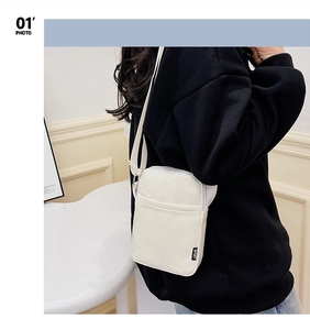 Detailed view of the white nylon fabric crossbody bag with a functional front zipper pocket