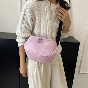 Vue détaillée du sac croissant en nylon rose avec bandoulière réglable sur modèle