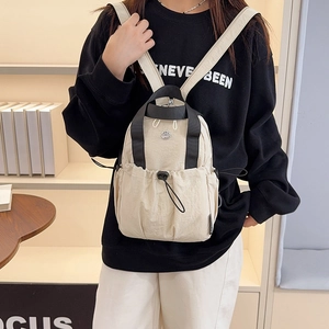Minimalist beige nylon travel backpack for women with drawstring and metal logo