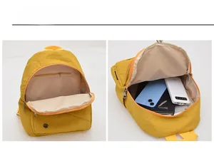 Detail view of yellow commuter backpack showing internal storage and hidden zipper pocket