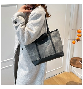 Détail du cabas bicolore en toile gris foncé avec des finitions en cuir noir