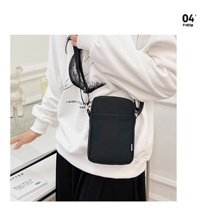 Detail of a minimalist black nylon crossbody phone bag with adjustable strap for women