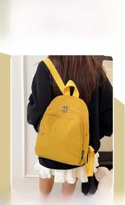 Rear view of ginger yellow nylon backpack on model showing casual minimalist style