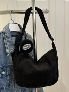 Minimalist black corduroy hobo shoulder bag with a round coin purse and fashion detail