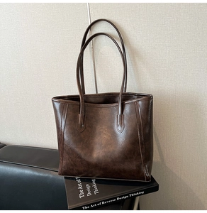 Detailed close-up of dark brown faux leather tote with vintage oil wax texture and stitching