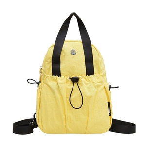 Bright yellow lightweight nylon travel backpack with black webbing handles and drawstring