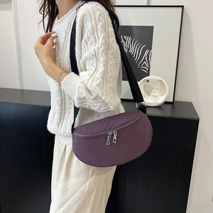 Détail du sac demi-lune en tissu oxford violet avec sangle réglable et fermetures éclair argentées