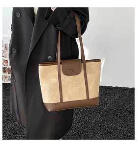 Détail d'un mannequin portant un grand sac cabas bicolore beige et marron texturé
