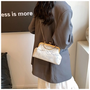Detail of landscape pattern on elegant metal frame handbag with gold chain strap