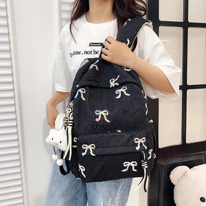 Quilted black backpack with colorful bow embroidery and a cute white cloud pendant