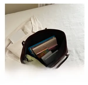 Top-down view of the spacious interior of the brown leather tote bag with various items