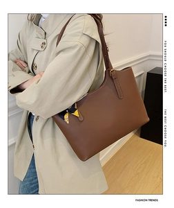 Close-up of brown leather tote bag with silk scarf detail and golden metal hardware