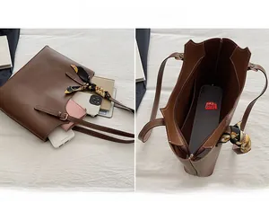 Detailed view of brown tote bag interior compartment with silk scarf handle decoration